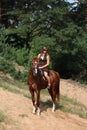 Girl in dress and brown horse portrait in forest Royalty Free Stock Photo