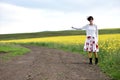 Girl in dress hitchhiking near a countryside road Royalty Free Stock Photo