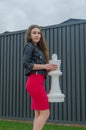 Girl in a dress and leather jacket on the Grand chessboard Royalty Free Stock Photo