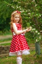 Girl in a dress near a flowering bush