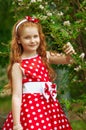 Girl in a dress near a flowering bush