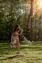 Girl in dress playing with dog in park at sunset Royalty Free Stock Photo