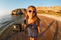 Girl in dress shoots video on action camera on a wild beach Royalty Free Stock Photo