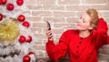 Girl in dress sit near christmas tree with ornaments. Wishing everyone merry christmas. Waiting for christmas. Voicemail Royalty Free Stock Photo