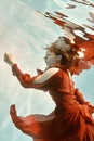 Portrait of a woman in a red dress floating underwater Royalty Free Stock Photo