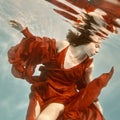 Portrait of a woman in a red dress floating underwater Royalty Free Stock Photo