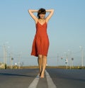 Girl in dress walk barefoot on empty road Royalty Free Stock Photo