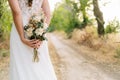 Girl dressed as a bride with a bouquet of preserved flowers in her hands on an out-of-focus background in nature. Royalty Free Stock Photo