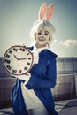 Girl dressed as a rabbit with clock. Royalty Free Stock Photo