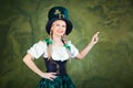 A girl dressed as St. Patrick points with her finger against a g Royalty Free Stock Photo