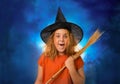 Surprised child witch with broomstick in the blue smoke Royalty Free Stock Photo