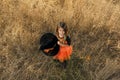 A girl dressed as a witch holds a huge black hat with an orange ribbon and looks up smiling sweetly. Royalty Free Stock Photo