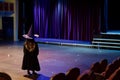 girl dressed as a witch practicing on a theater stage