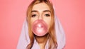 Girl dressed in blue hoodie and blowing bubble with chewing gum