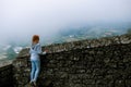 A girl dressed in a denim jacket and blue pants, posing against the backdrop of a medieval fortification. travel and vacation Royalty Free Stock Photo