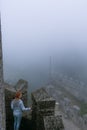 A girl dressed in a denim jacket and blue pants, posing against the backdrop of a medieval fortification. travel and vacation Royalty Free Stock Photo