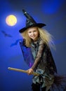 Girl dressed up as witch in night flying broom