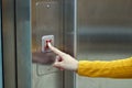 Girl dressed in yellow biting the elevator button