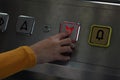 Girl dressed in yellow biting the elevator button