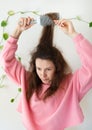 The girl dries her hair on a brush. Hair care. The concept of home care, drying healthy hair with a hair dryer and brush Royalty Free Stock Photo