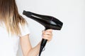 The girl dries her hair with a hairdryer on a white background, hair dryer and hair Royalty Free Stock Photo