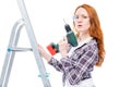 girl with a drill on a stepladder posing on a white