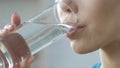 Girl drinking clean fresh mineral water glass, aqua body balance, hydration