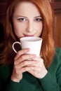 Girl drinking coffee near wood doors. Royalty Free Stock Photo