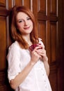 Girl drinking coffee near wood doors. Royalty Free Stock Photo