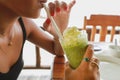 Girl drinking green tea smoothie with white cream over