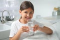 Girl drinking tap water from glass in kitchen Royalty Free Stock Photo