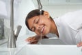 Girl drinking tap water over sink in kitchen Royalty Free Stock Photo