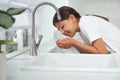 Girl drinking tap water over sink in kitchen Royalty Free Stock Photo