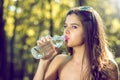 Girl drinking water from bottle in nature