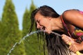 Girl drinking water from a hose