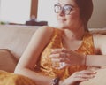 Girl drinking water sitting on a couch at home Royalty Free Stock Photo