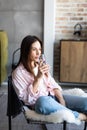 Young girl drinking water sitting on a couch at home and looking at camera Royalty Free Stock Photo