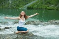 Girl drinks clear water from mountain river