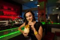 Girl drinks a Pina colada cocktail in night club