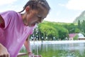 Girl drinks spring water from fountain. Drinking mineral water in fresh air. Royalty Free Stock Photo