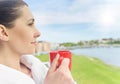 Girl drinks tea on a background sea landscape. Royalty Free Stock Photo