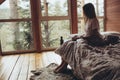 The girl drinks tea in nature. A beautiful young girl stands at the window and holds a cup of tea in her hands. Royalty Free Stock Photo