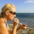 Girl drinks from tubule on beach