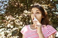 Girl drips blocked nose from allergy. Woman with Respiratory Spray for nose in Spring Blooming. Portrait of a woman having respira Royalty Free Stock Photo