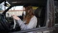 A female driver puts on a face mask in the car