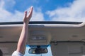 Girl driver traveling by car and holds her hand out from open hatch of a vehicle.