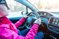 Girl drives car in winter. The concept of driving and traveling in winter conditions