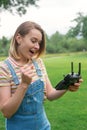 The girl drives a quadrocopter in the park. Flights in the park. Fun spending time