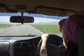 Girl driving on the autobahn, moving towards the sun in a mountainous area, the problem of poor visibility of the road