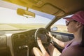 Girl driving on the autobahn, moving towards the sun in a mountainous area, the problem of poor visibility of the road Royalty Free Stock Photo